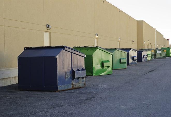 a fleet of red and blue construction dumpsters available for use in Belmont